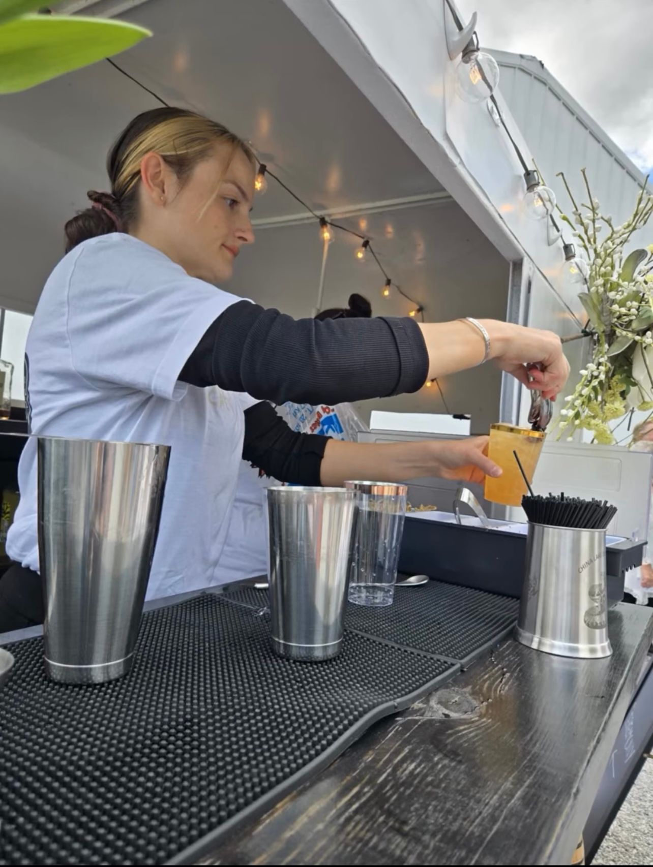 Two bartenders working inside the mobile bar trailer